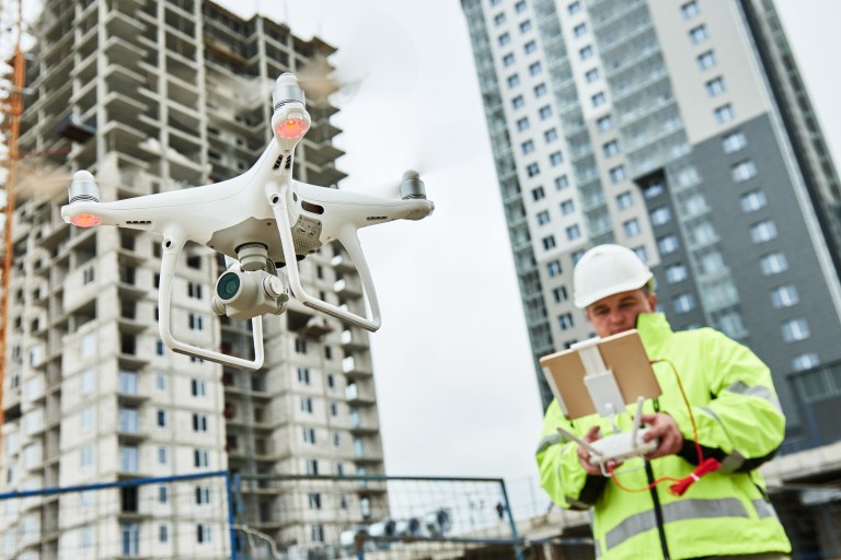 Drone operated by construction worker on building site