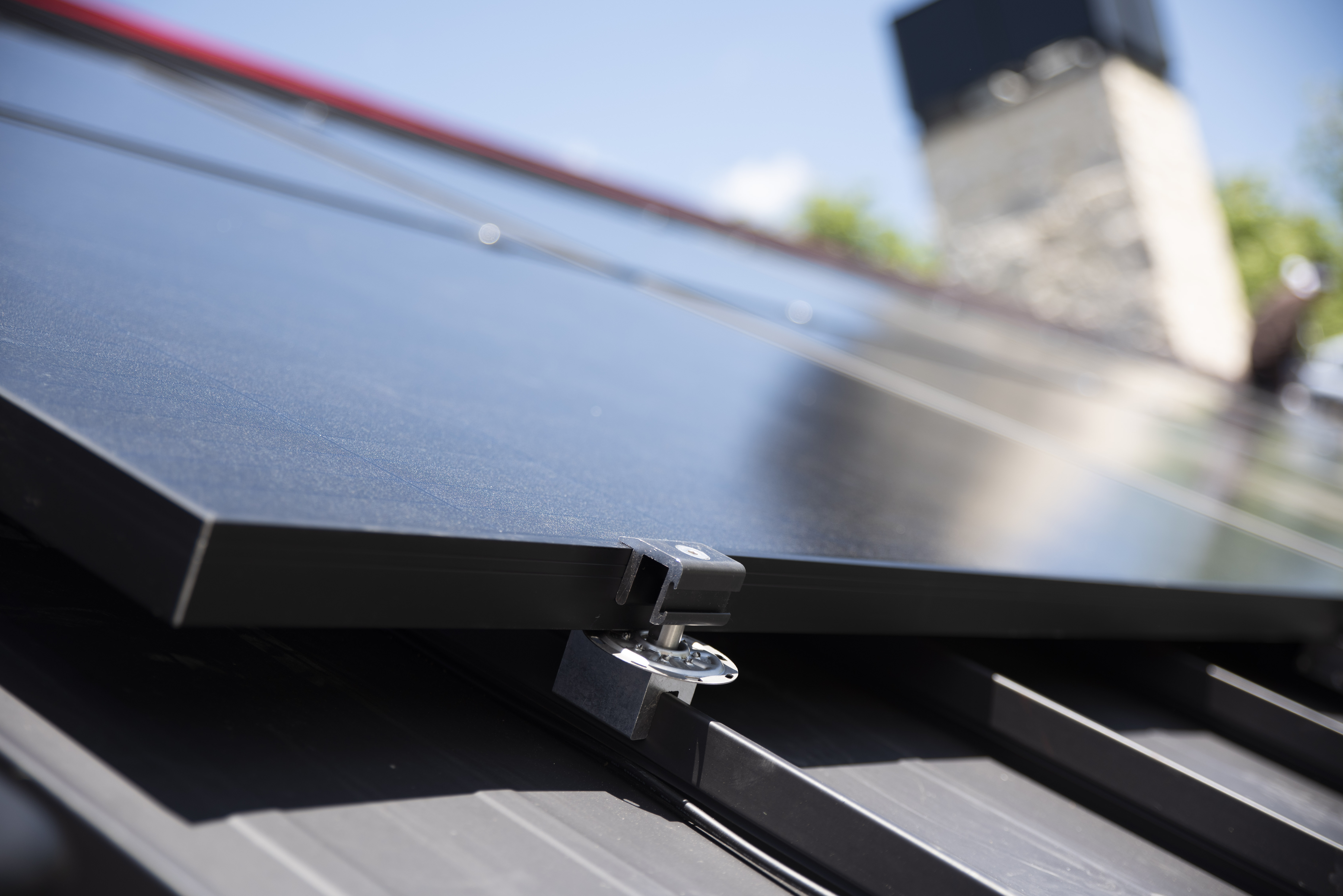 Non-penetrating clamp securing solar panels to a standing seam metal roof. 