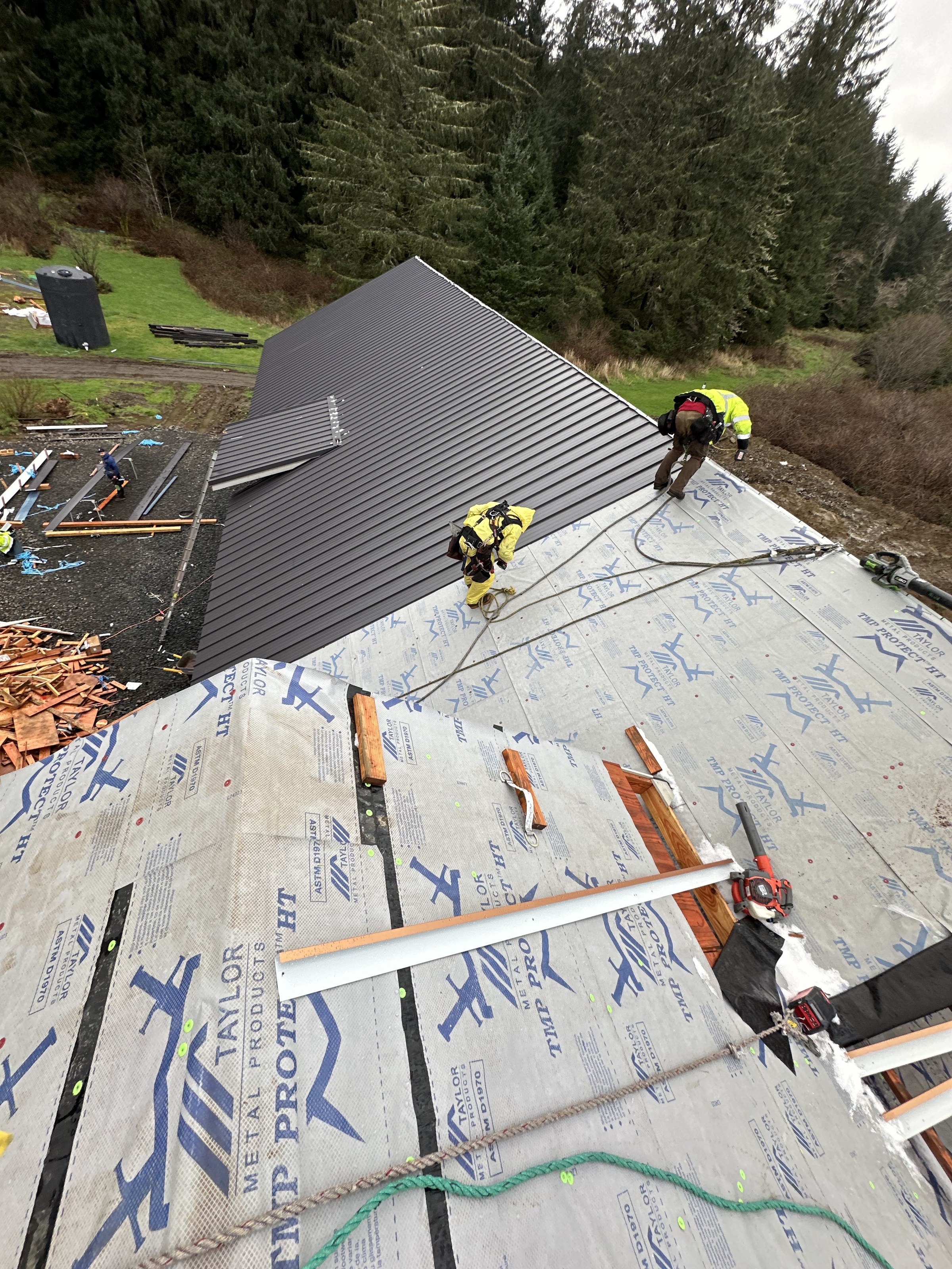 Crew working in full fall protection on a metal install Crew working in full fall protection on a metal install